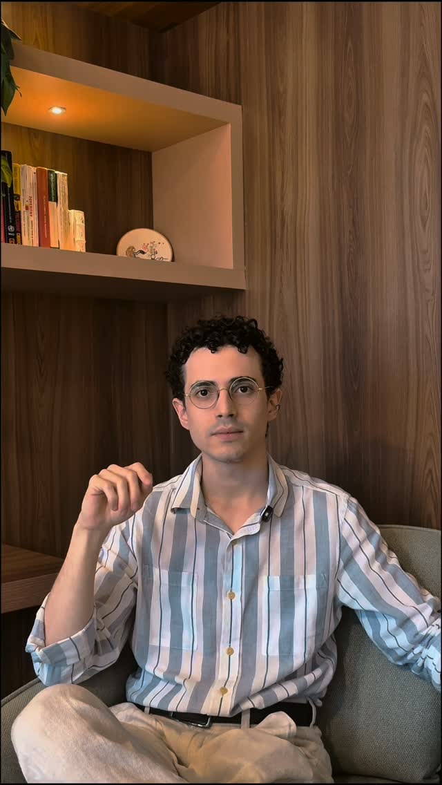 Dr. Paulo Levi sentado em uma poltrona, com camisa listrada azul.