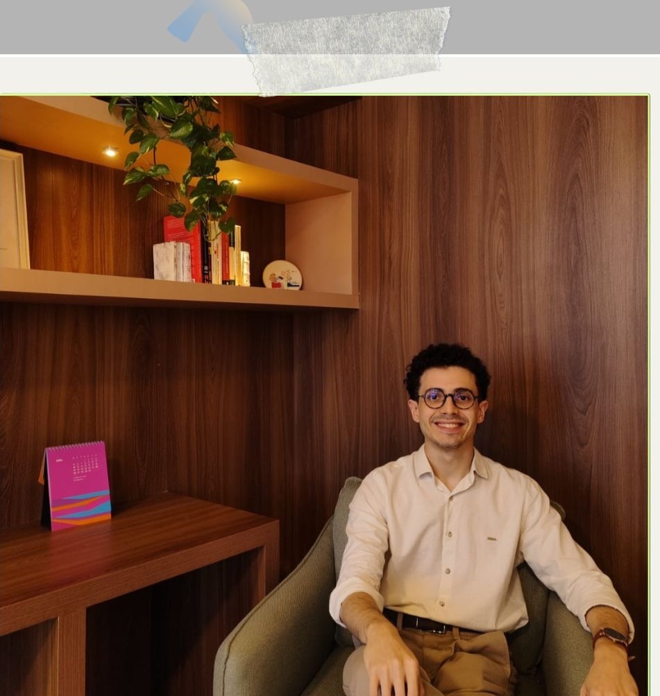 Dr. Paulo Levi sorrindo, sentado à mesa de madeira.